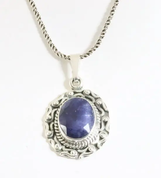 Bewerkte zilveren hanger met blauwe saffier aan ketting