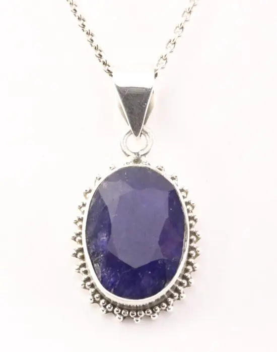 Bewerkte zilveren hanger met blauwe saffier aan ketting