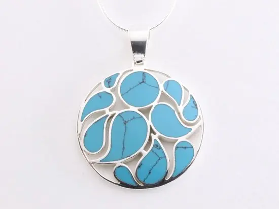 Ronde opengewerkte zilveren hanger met blauwe turkoois aan ketting